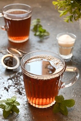 Two cups of tea beside a sugar