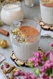 Cup of sahlab with cinnamon and nuts on it