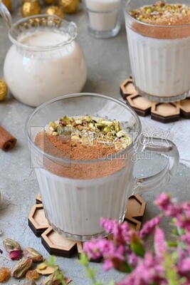 Cup of sahlab with cinnamon and nuts on it