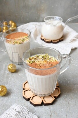 Cup of sahlab with cinnamon and nuts on it
