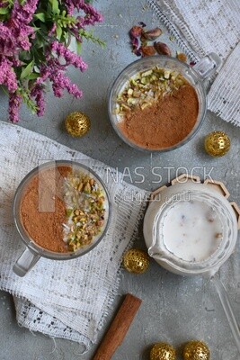 Cup of sahlab with cinnamon and nuts on it