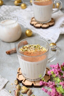 Cup of sahlab with cinnamon and nuts on it
