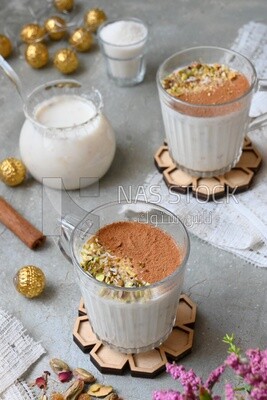Two cups of sahlab with cinnamon and nuts on it