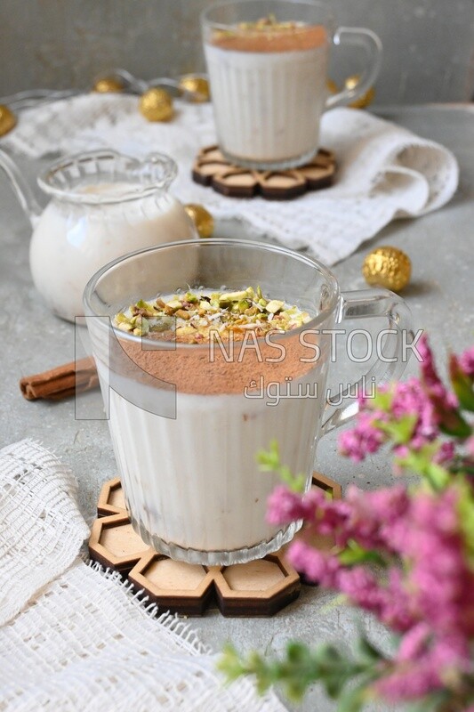 Cup of sahlab with cinnamon and nuts on it