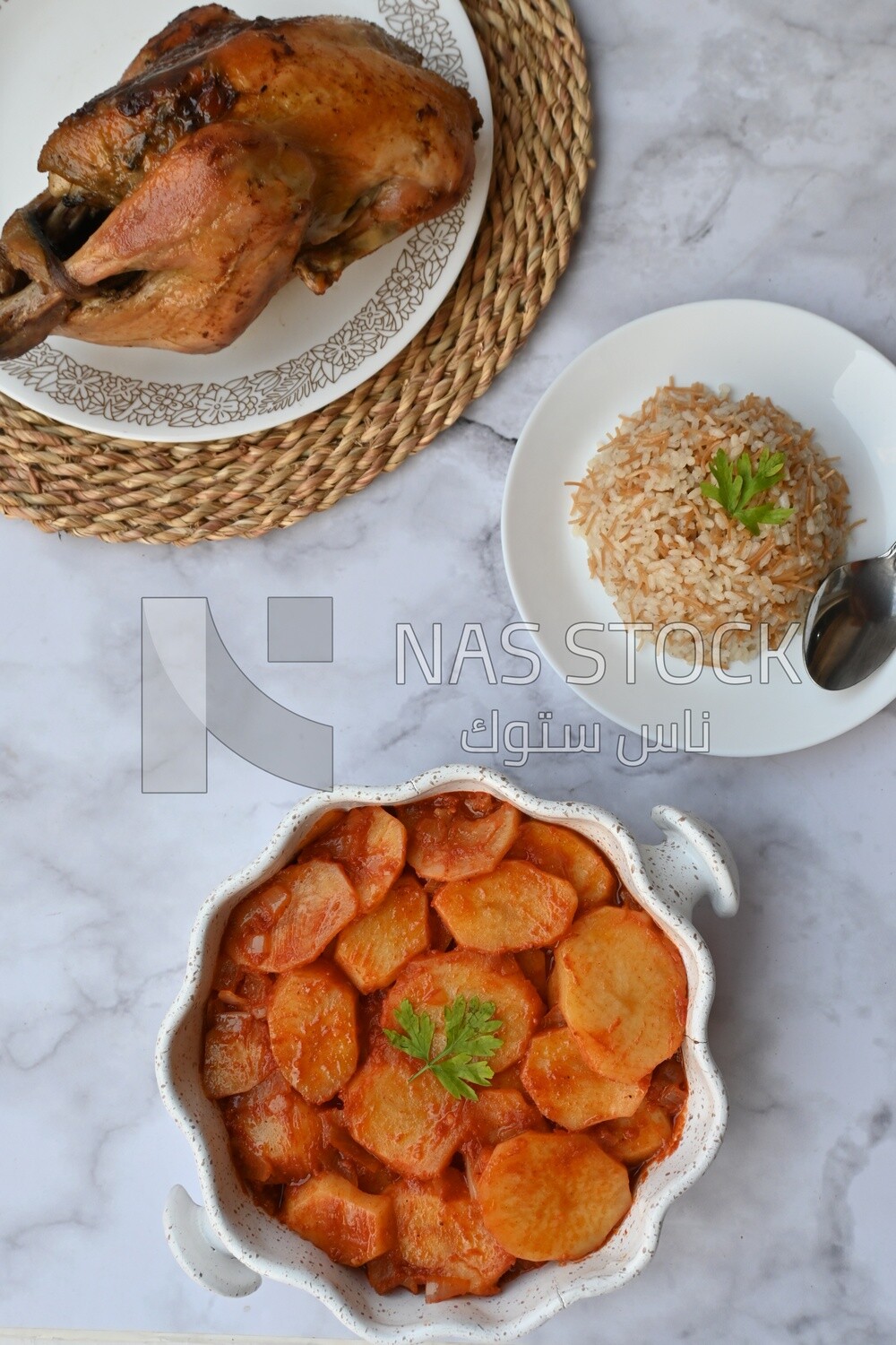 Potato tray sits beside a plate of rice and chicken