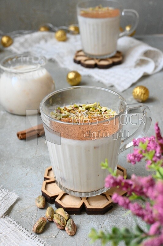Cup of sahlab with cinnamon and nuts on it