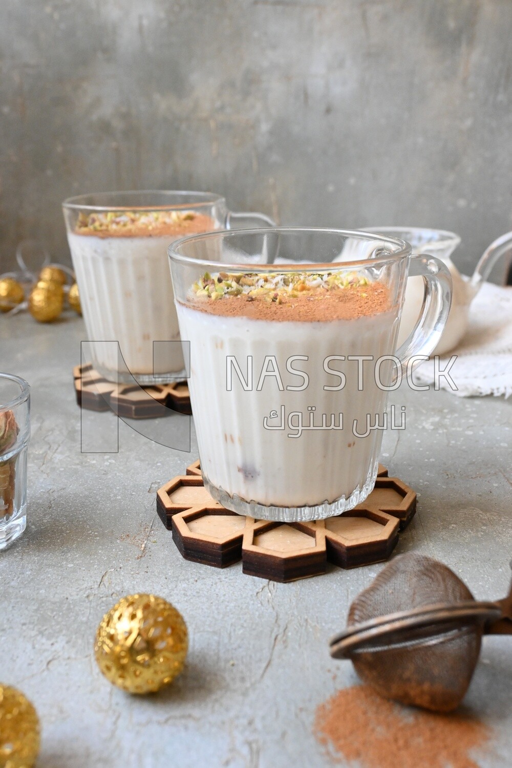 Cup of sahlab with cinnamon and nuts on it