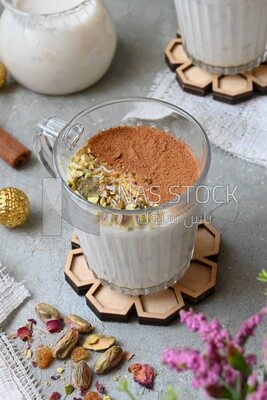 كوب سحلب مع قرفة و مكسرات عليه