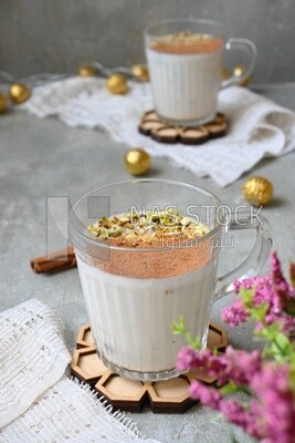 Cup of sahlab with cinnamon and nuts on it