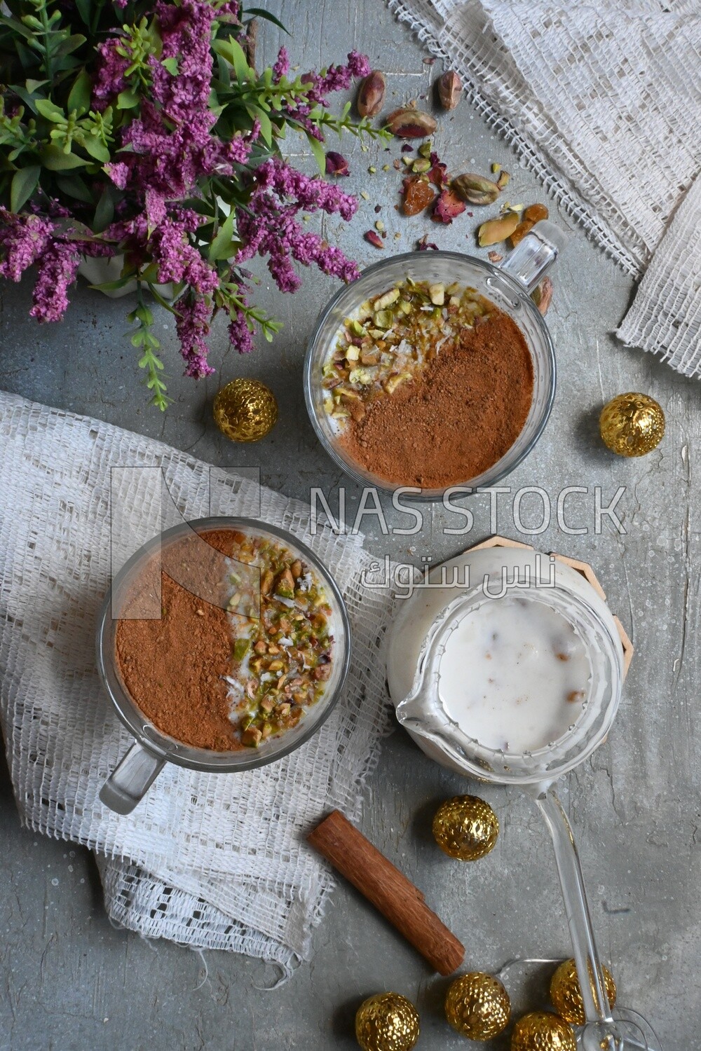 Two cups of sahlab with cinnamon and nuts on it