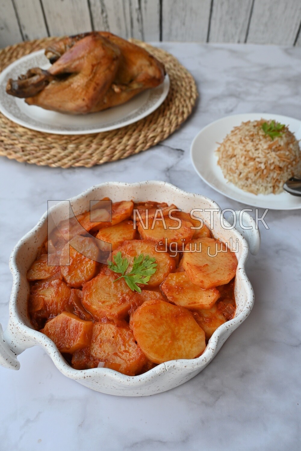 Potato tray sits beside a plate of rice and chicken