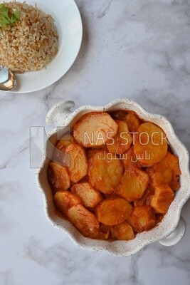 Potato tray sits beside a plate of rice