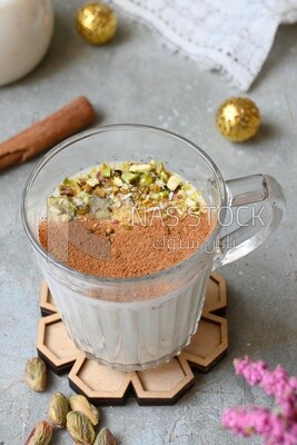 Cup of sahlab with cinnamon and nuts on it