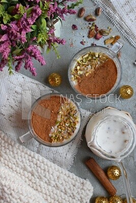 Two cups of sahlab with cinnamon and nuts on it