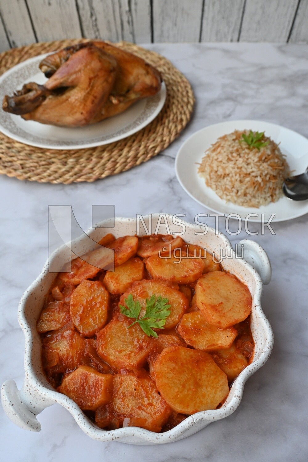Potato tray sits beside a plate of rice and chicken