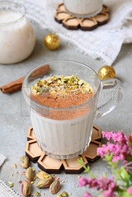 Cup of sahlab with cinnamon and nuts on it