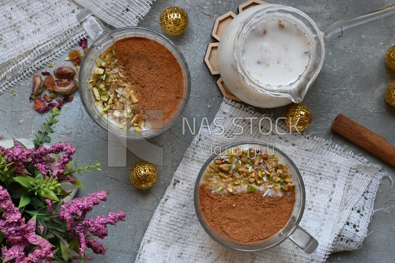 Two cups of sahlab with cinnamon and nuts on it