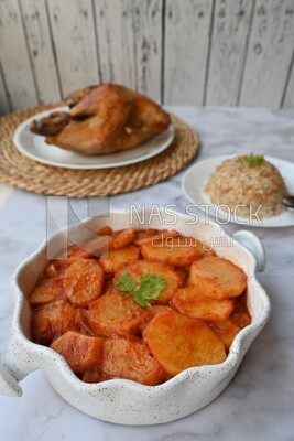 Potato tray sits beside a plate of rice and chicken