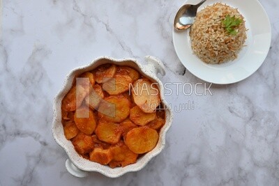 صينية بطاطس بجانب طبق ارز