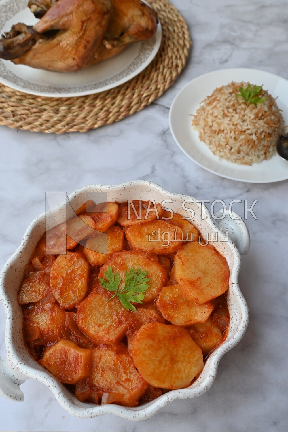 Potato tray sits beside a plate of rice and chicken