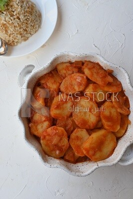 Potato tray sits beside a plate of rice