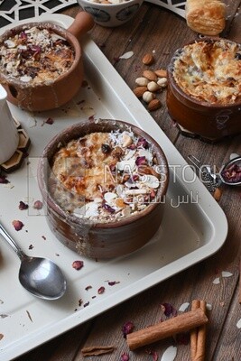 Plate of om ali with nuts on it next to cinnamon