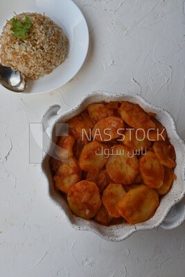 Potato tray sits beside a plate of rice