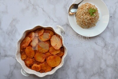 صينية بطاطس بجانب طبق ارز