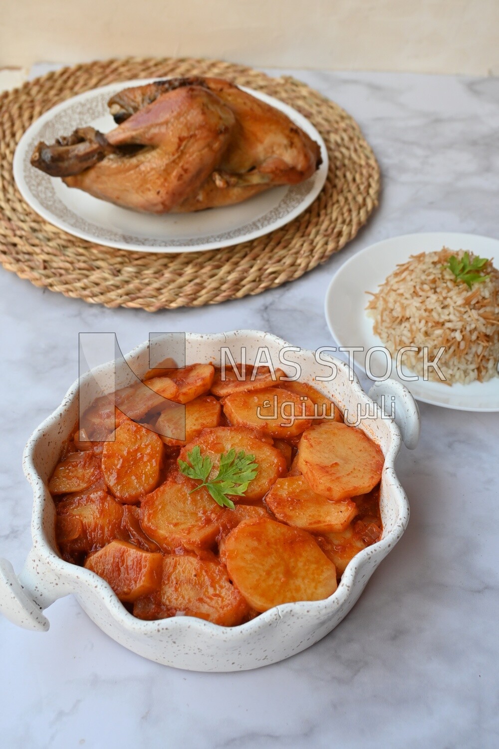 Potato tray sits beside a plate of rice and chicken