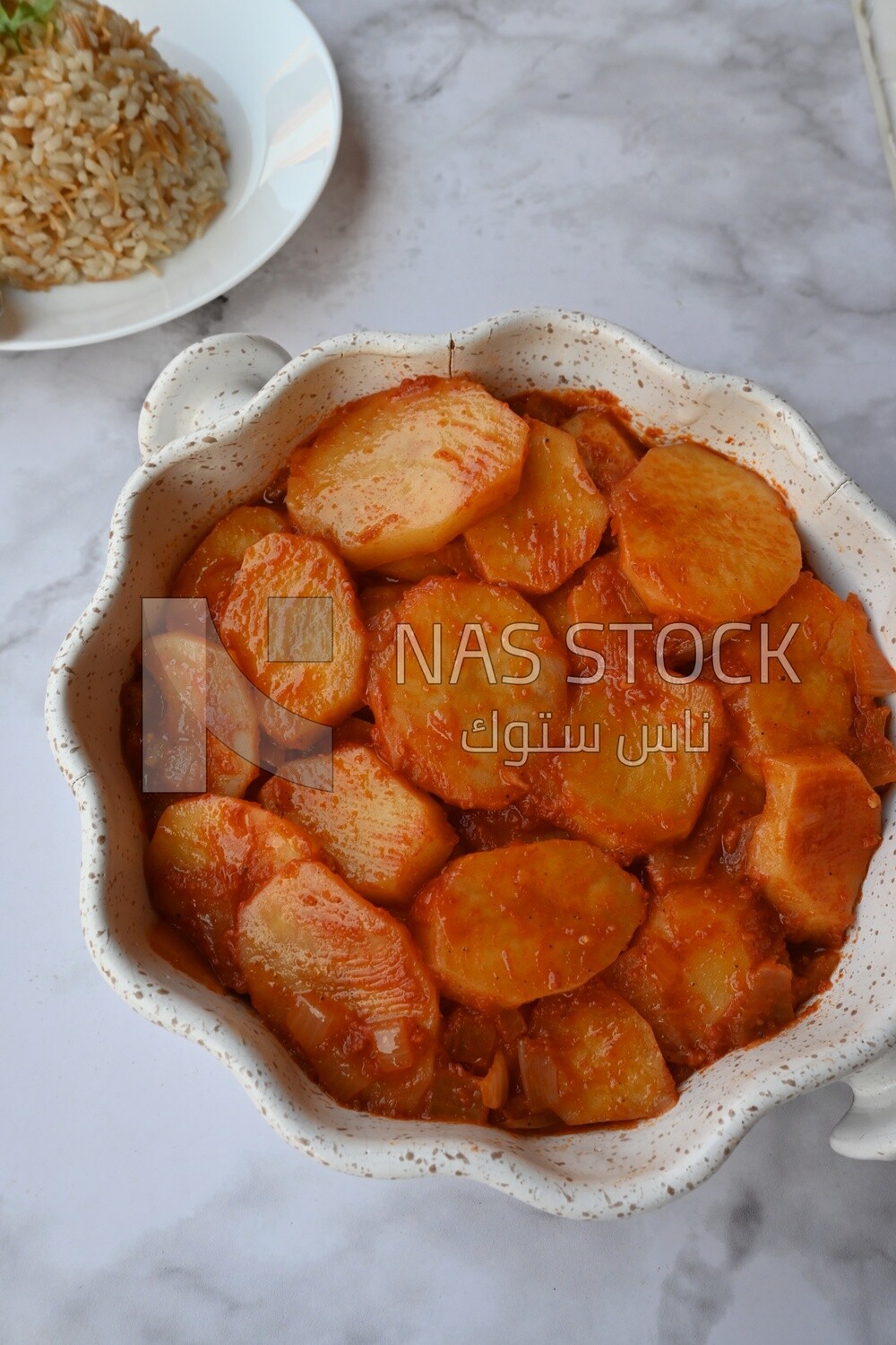 Potato tray sits beside a plate of rice