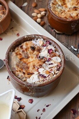 Plate of om ali with nuts on it next to cinnamon