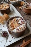 Close up of a plate of Umm Ali with nuts on it, cinnamon sticks, famous oriental Arabic sweets, bread and milk sweets