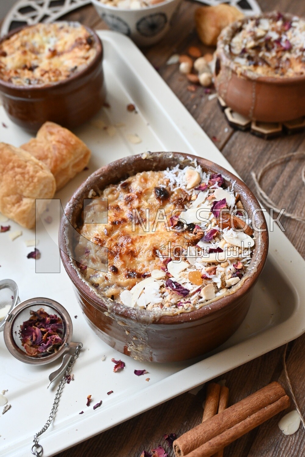 Plate of om ali with nuts on it next to cinnamon