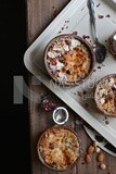 Plate of Umm Ali with nuts on it, cinnamon sticks, famous oriental Arabic sweets, bread and milk sweets