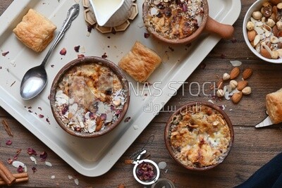 Plate of Umm Ali with nuts on it, famous oriental Arabic sweets, bread and milk sweets