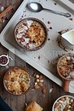 Top view of a plate of Umm Ali with nuts on it, cinnamon sticks, famous oriental Arabic sweets, bread and milk sweets