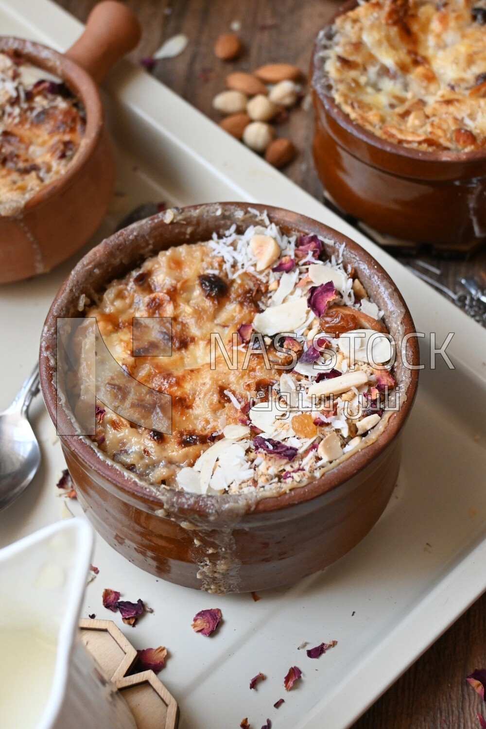 Plate of om ali with nuts on it next to cinnamon