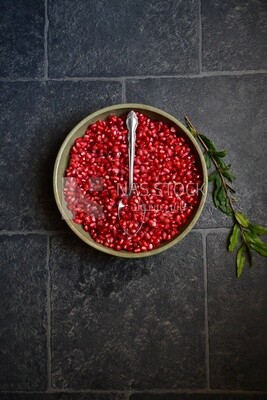 Bowl of pomegranates with a spoon