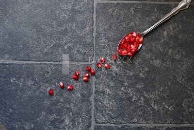 Seeds of pomegranates​​ in a spoon