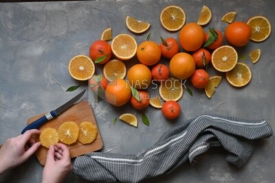Oranges with a knife and orange slices on the table ​
