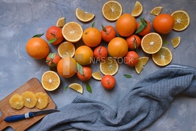 Oranges with a knife and orange slices on the table ​