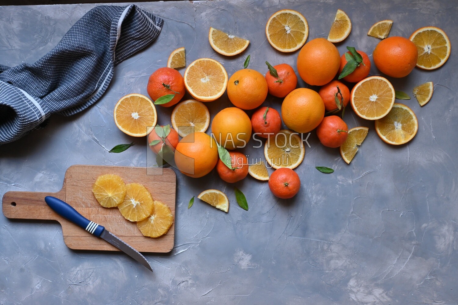 Oranges with a knife and orange slices on the table ​