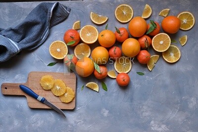 Oranges with a knife and orange slices on the table ​