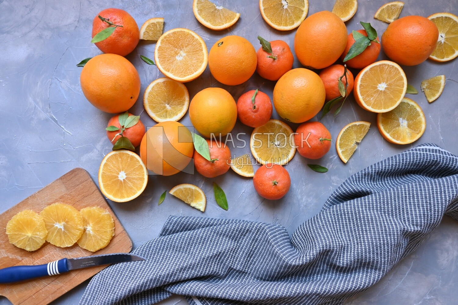 Oranges with a knife and orange slices on the table ​