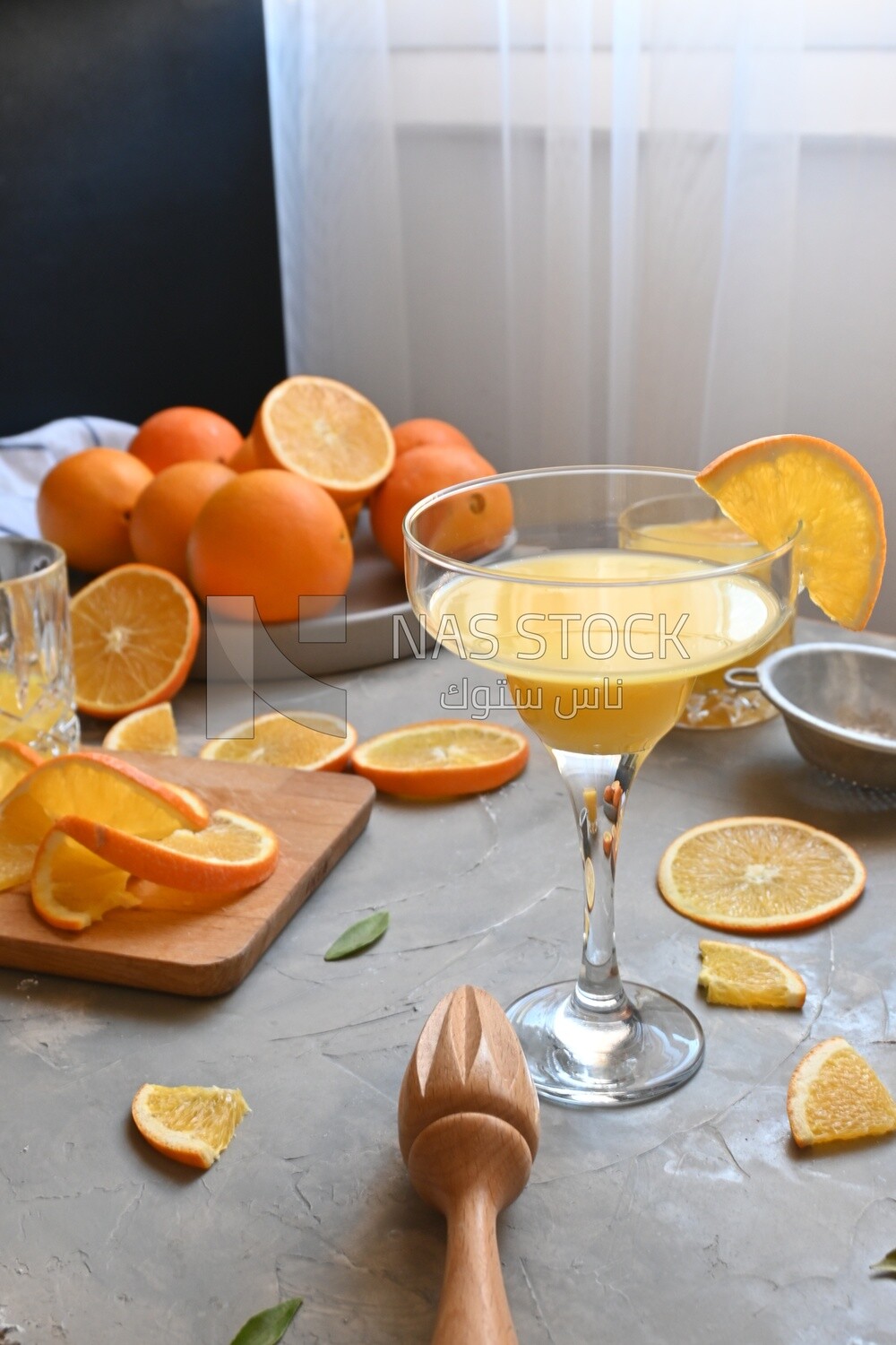Glass of orange juice with a wooden citrus juicer