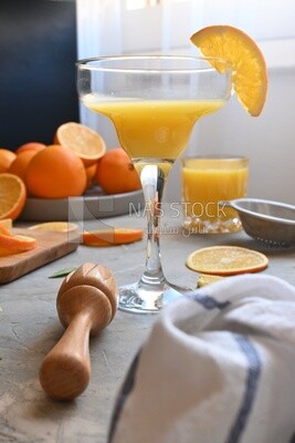 Glass of orange juice with a wooden citrus juicer