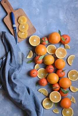 Oranges with a knife and orange slices on the table ​