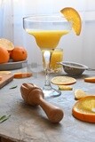 Glass of orange juice with a wooden citrus juicer