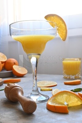 Glass of orange juice with a wooden citrus juicer