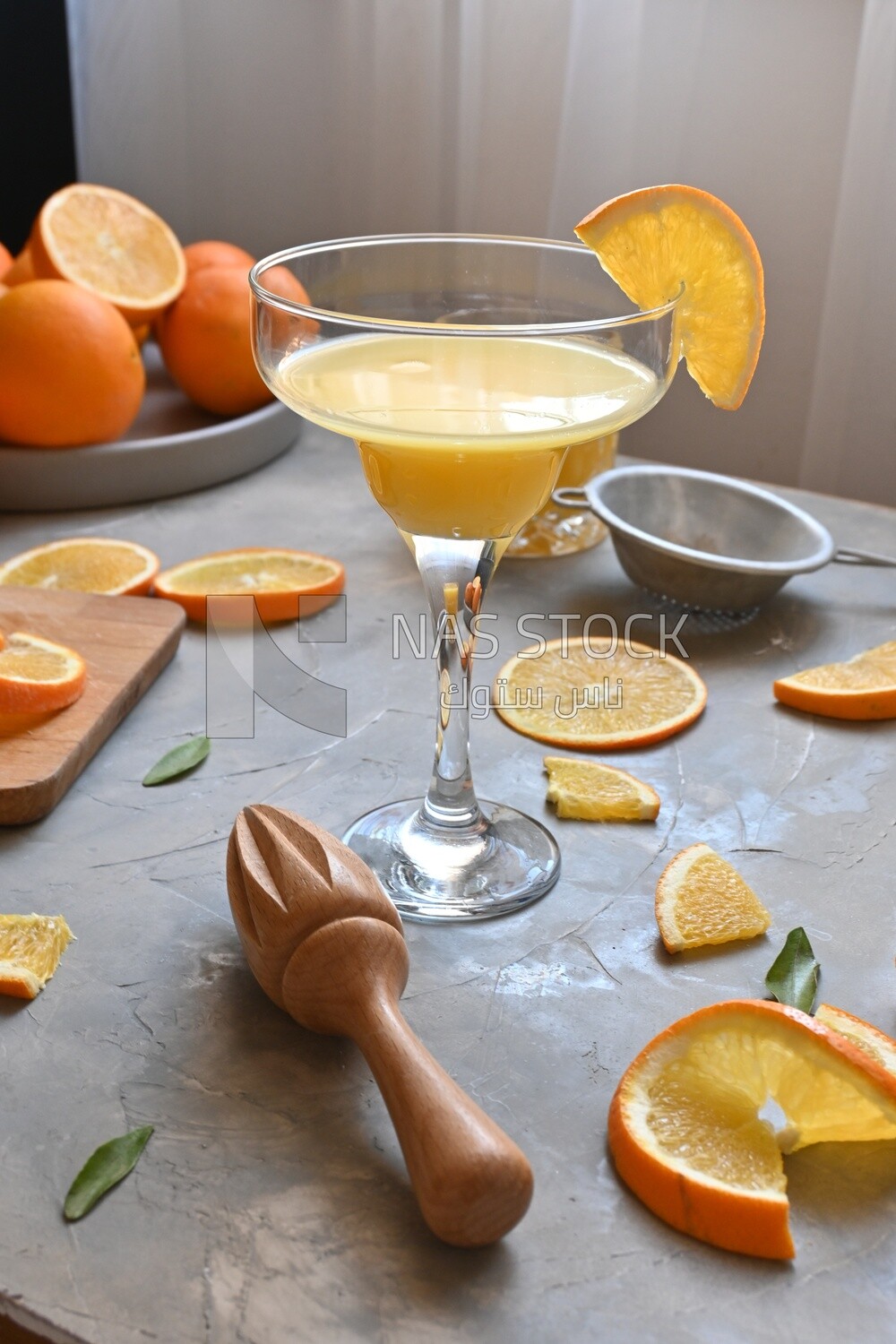 Glass of orange juice with a wooden citrus juicer